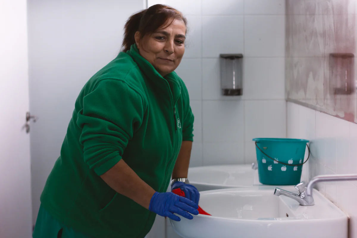Una trabajadora de Máis Porvir limpiando los lavabos de un centro